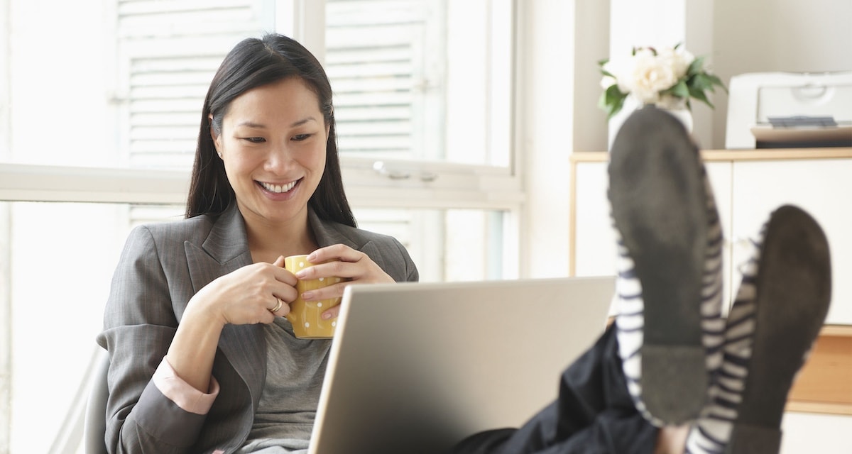 Businesswoman working at desk with feet up