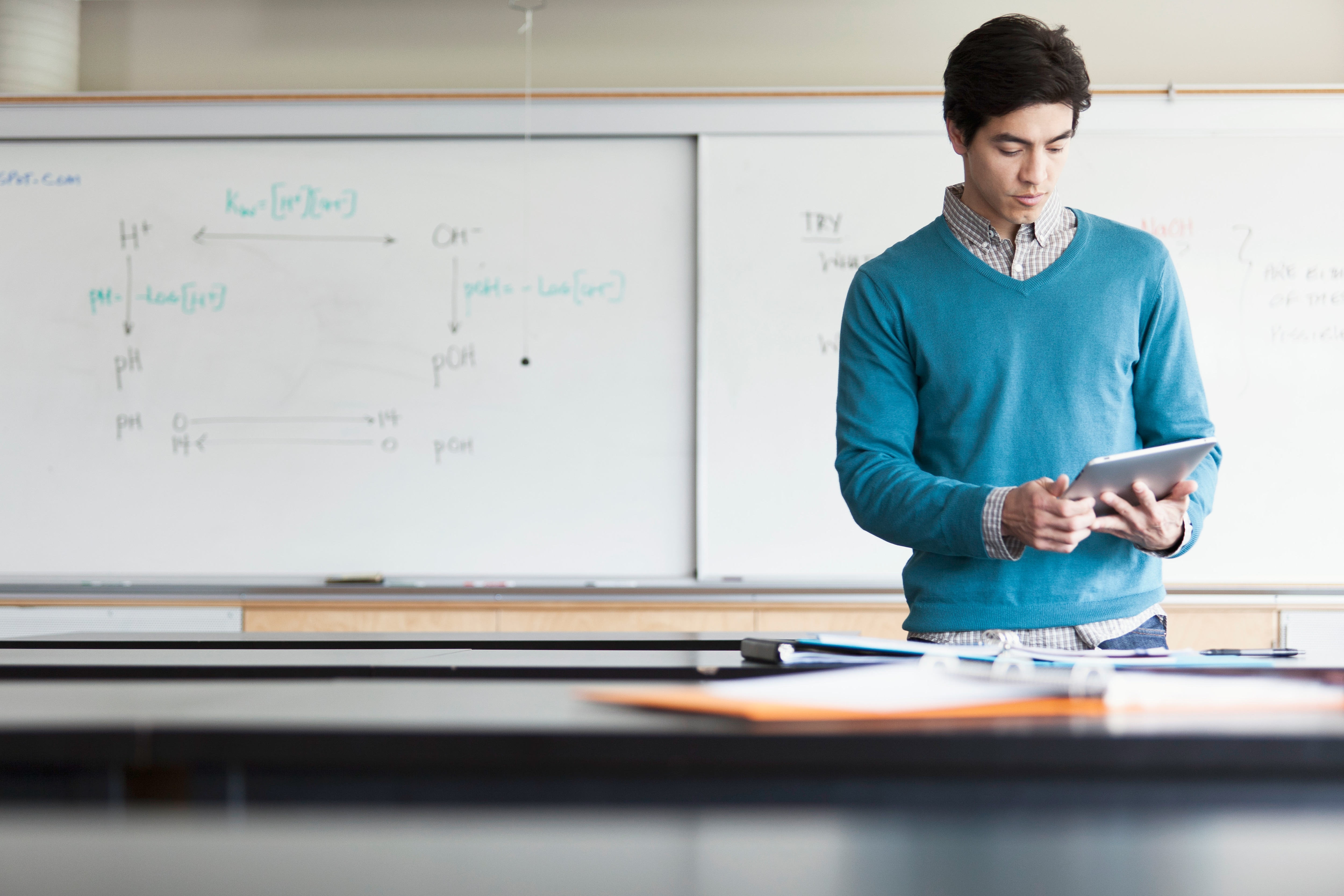 Professor working on tablet in front of whiteboard