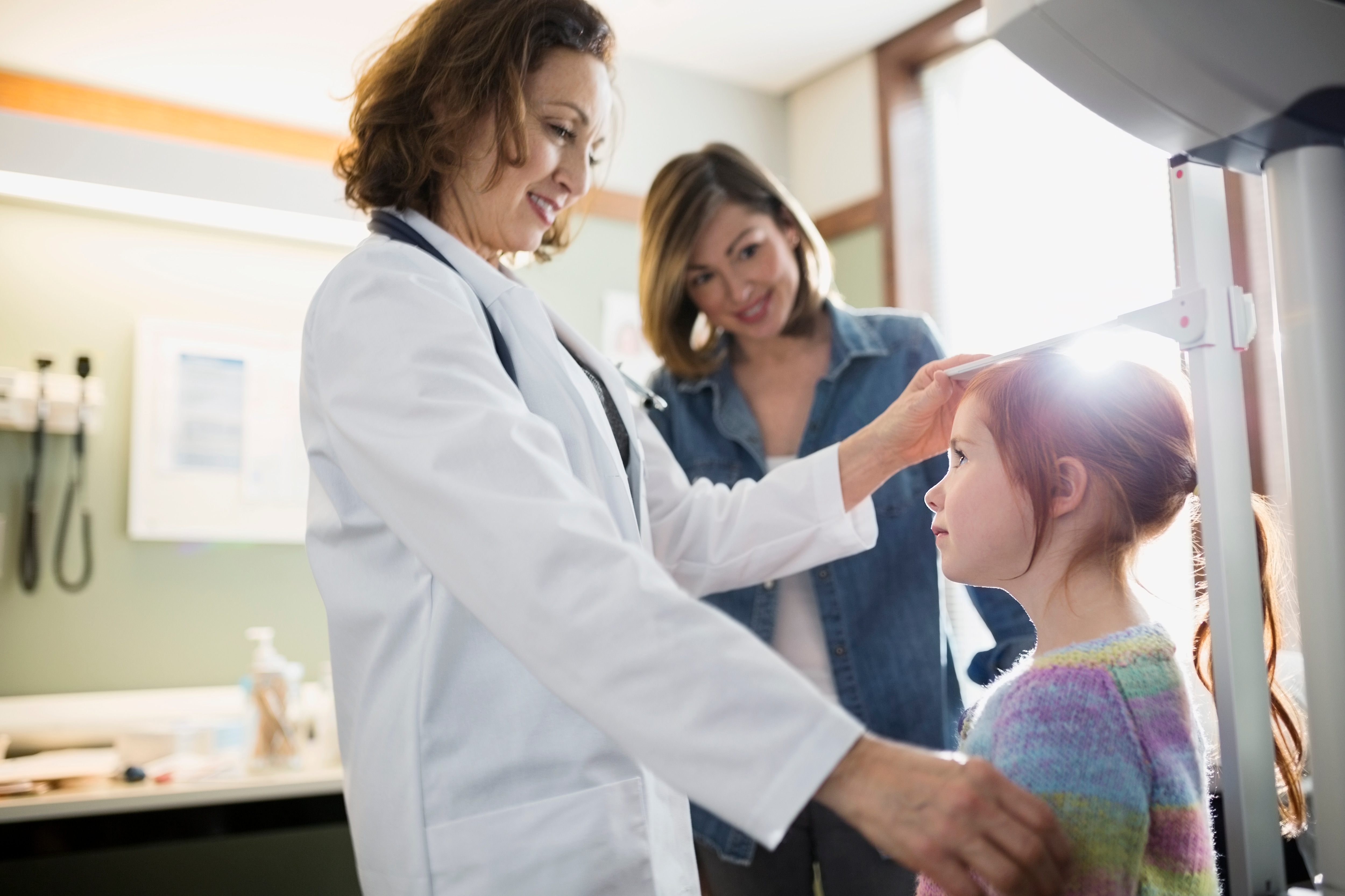 Doctor measuring the height of a young girl