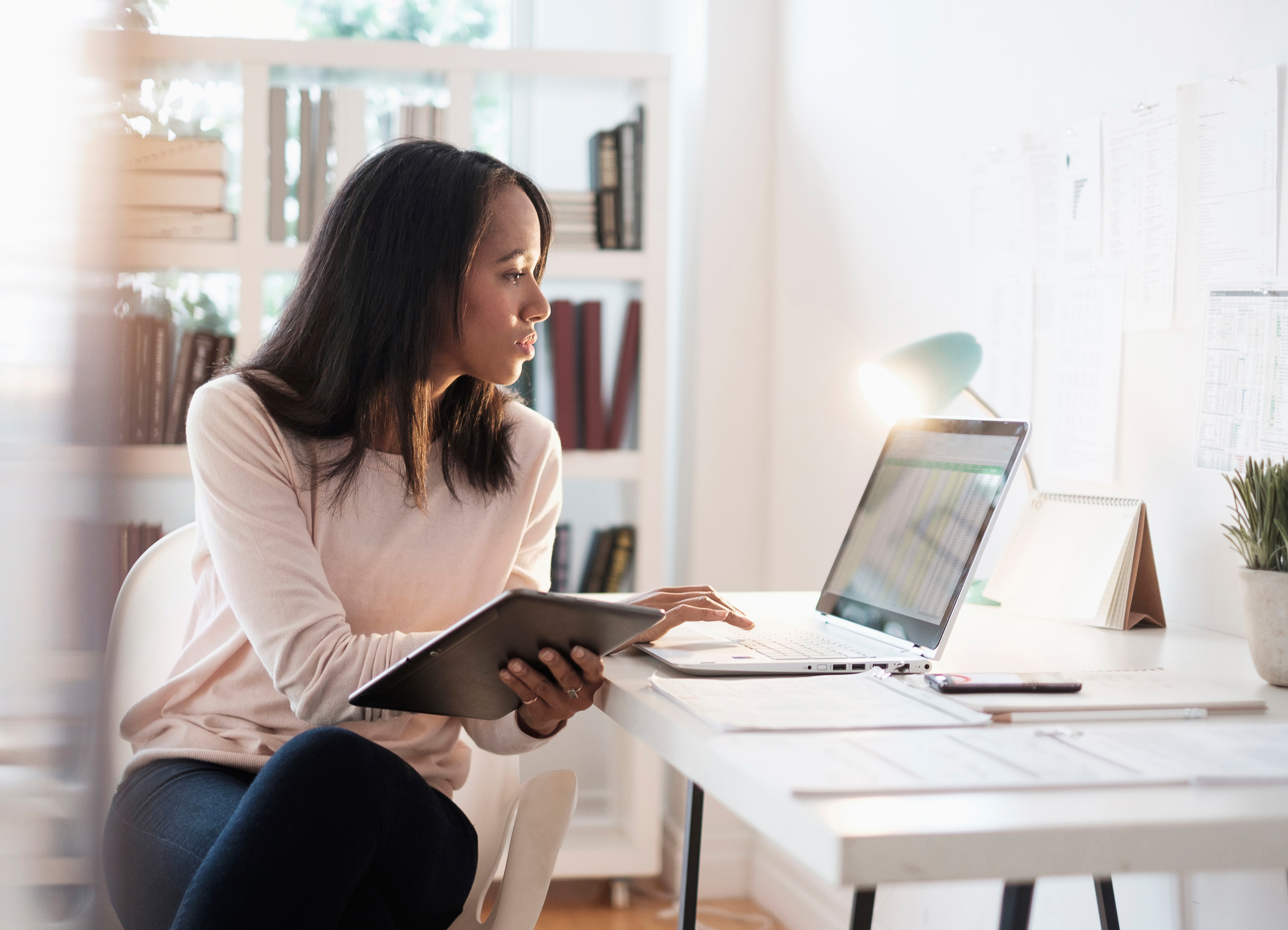 Woman looking at computer screen reading the tip sheet to optimize expenses