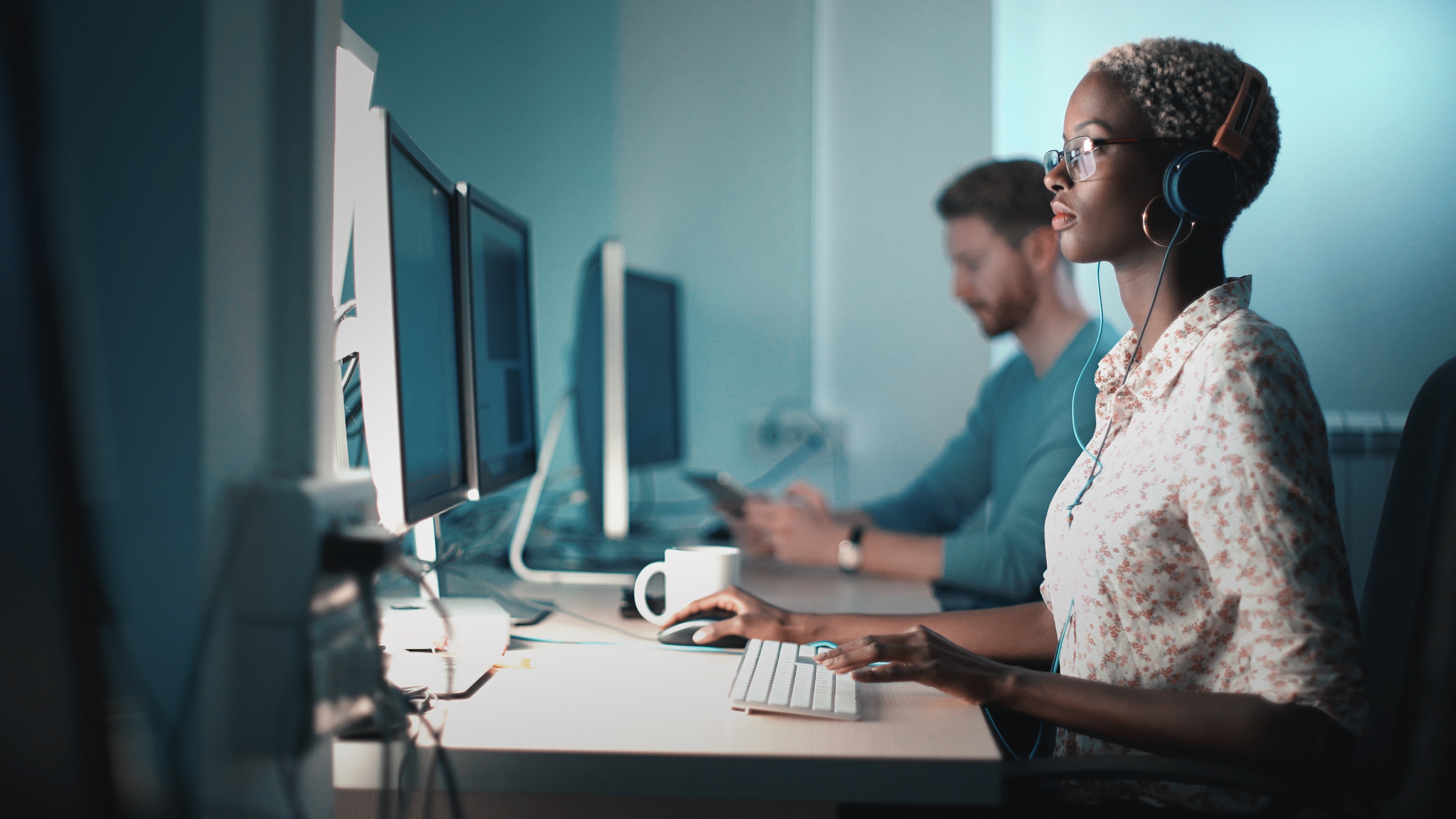 Woman working on computer with headphones on