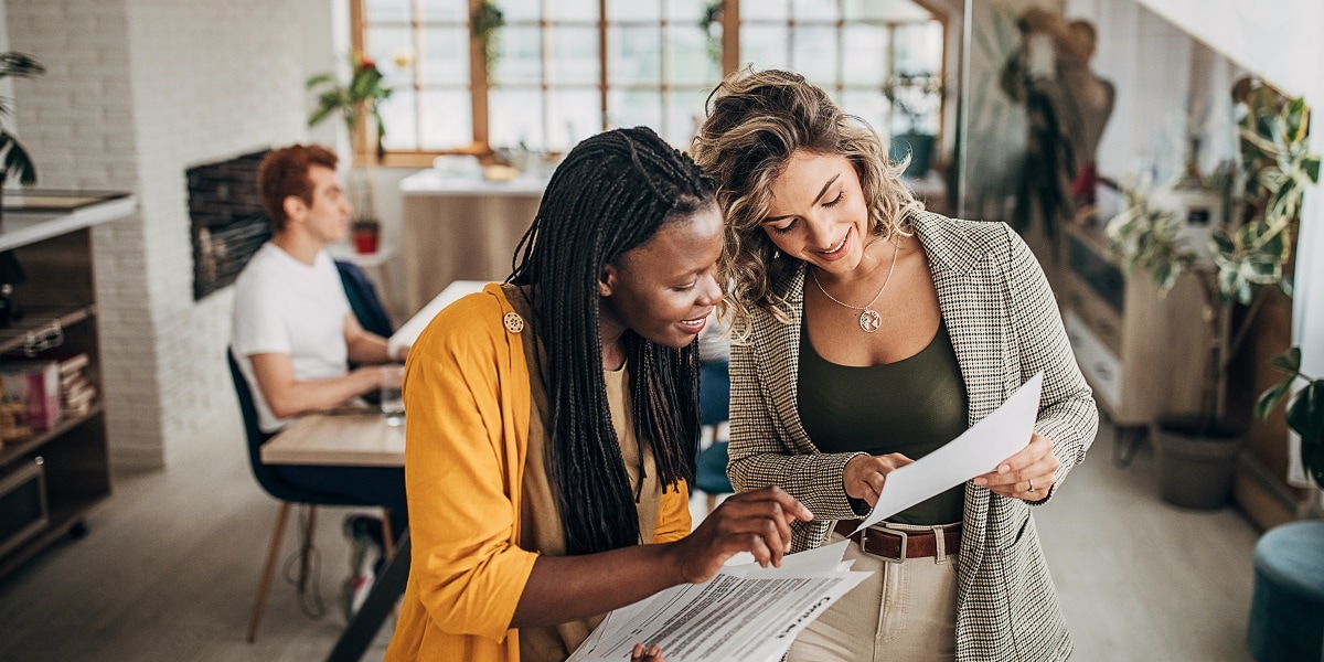 Two people in an office environment sharing information 