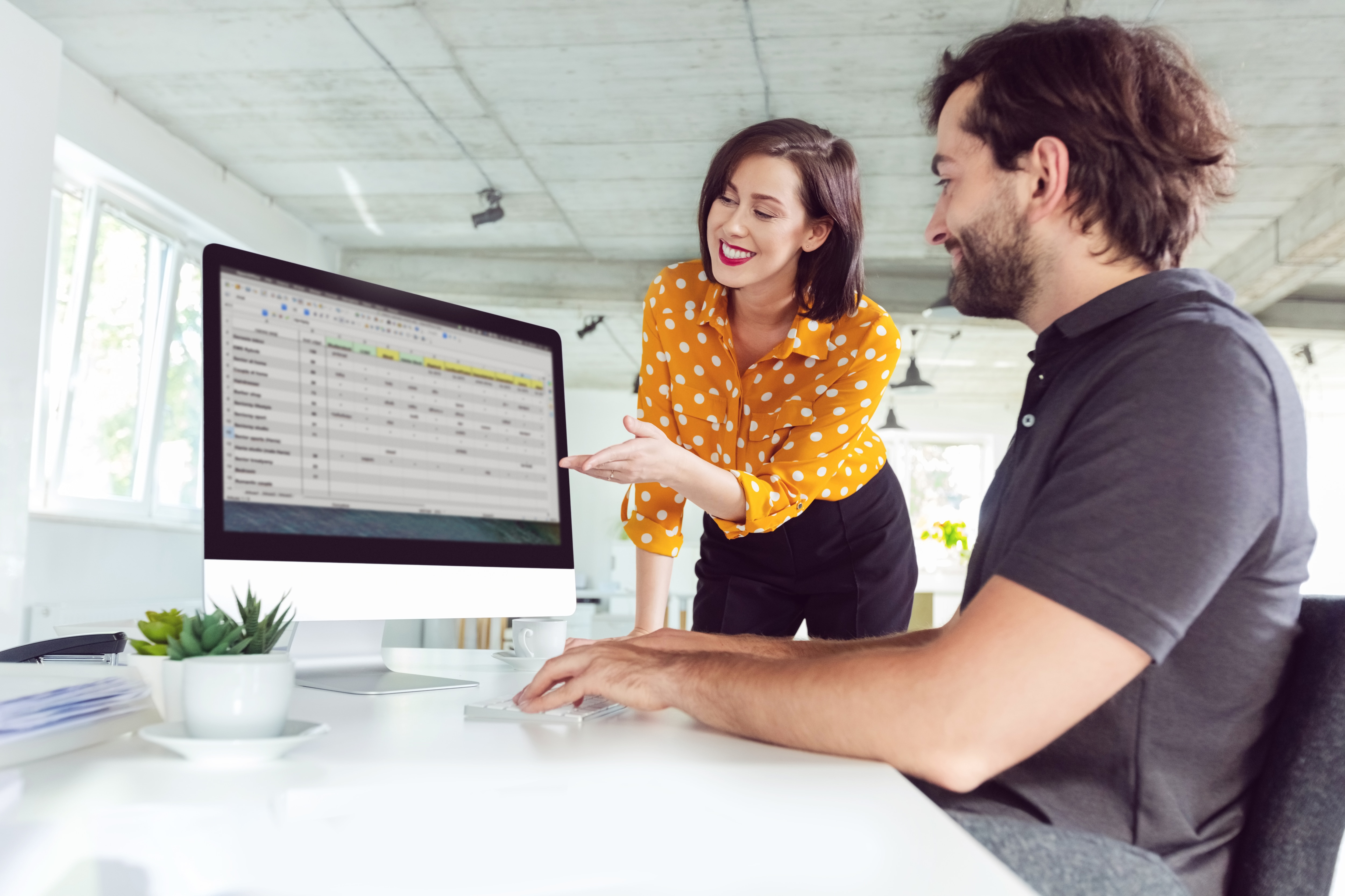 a man and a woman looking at the monitor