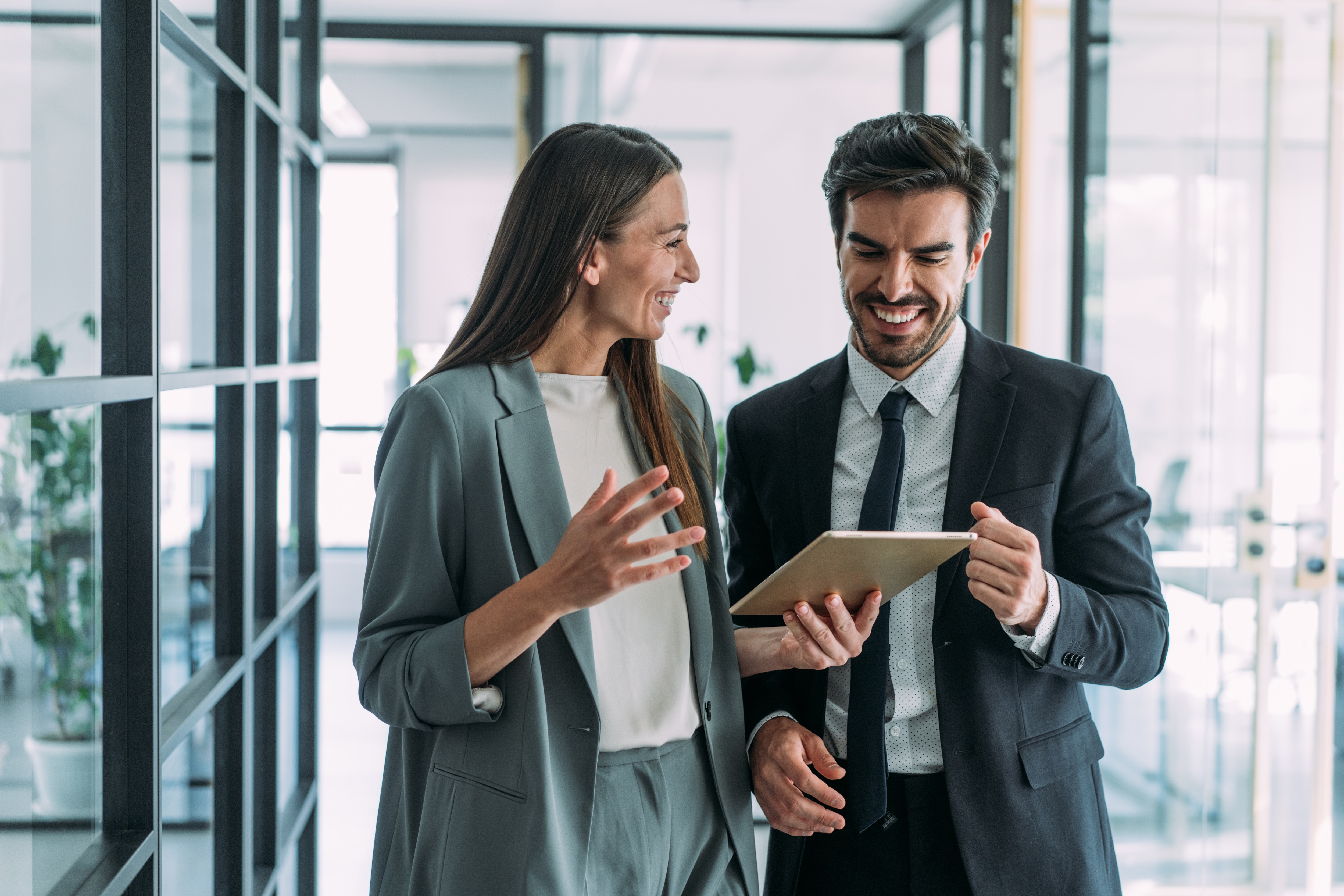 Two people walking and talking in an office