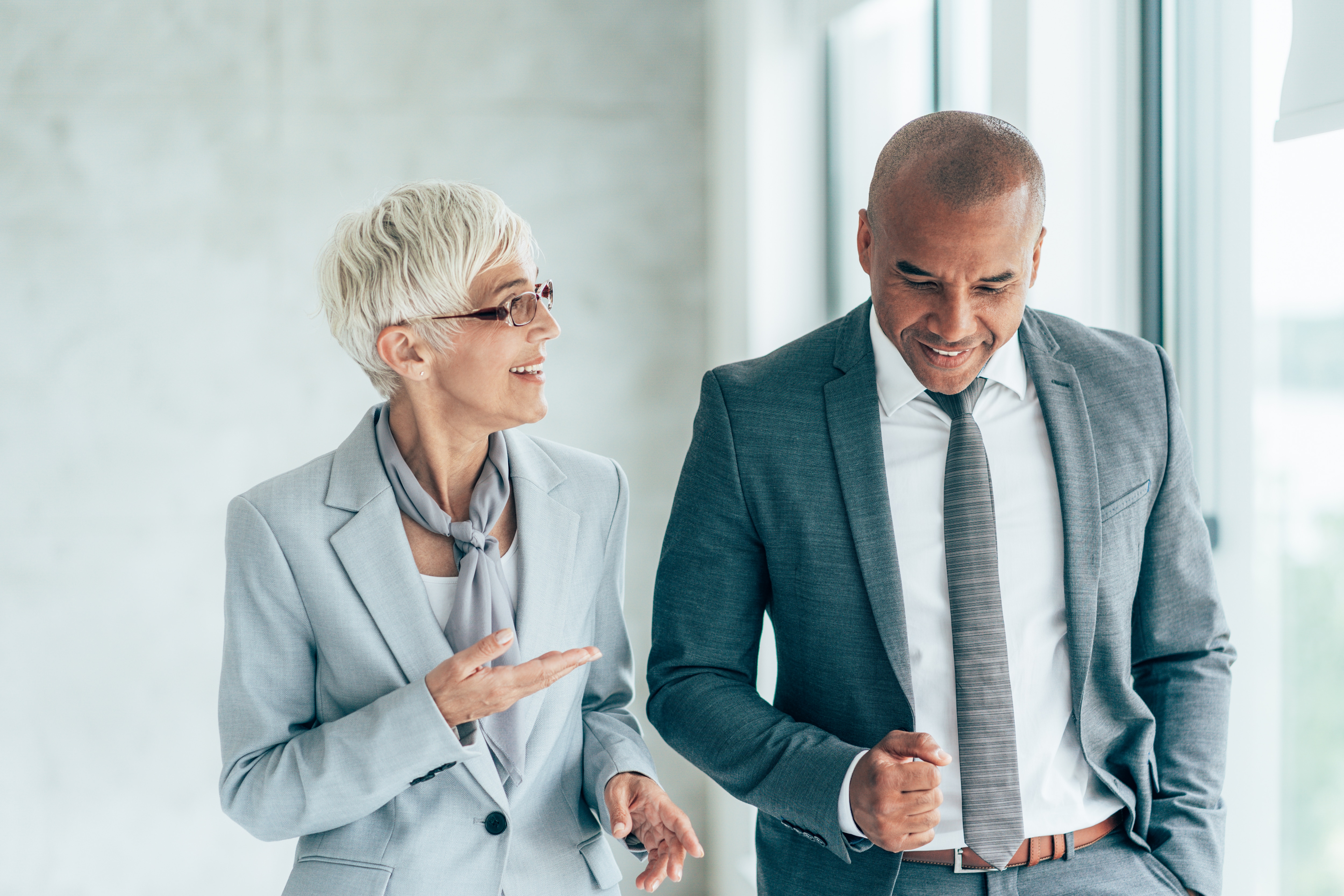 A woman and man chatting about business in office