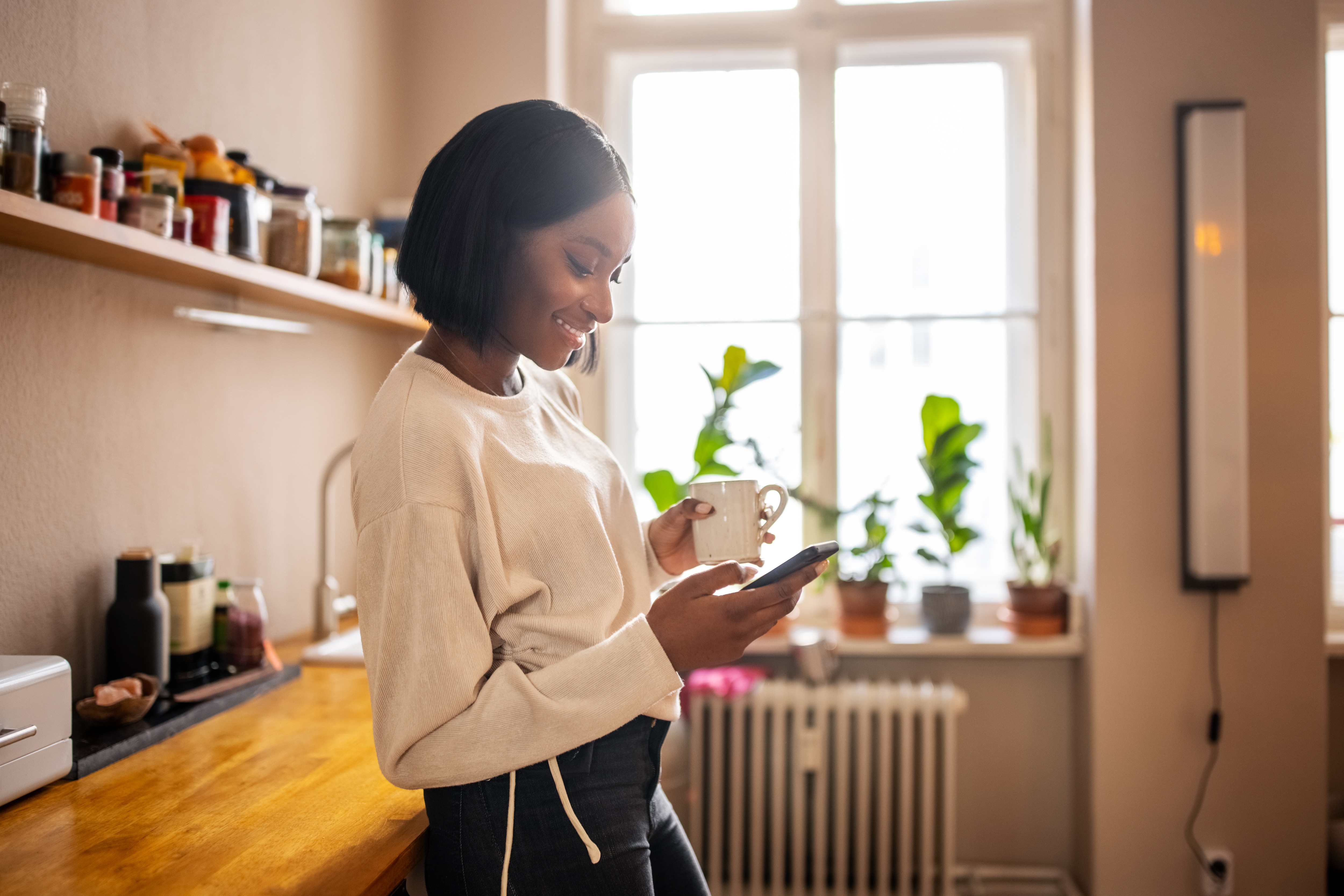 woman looking at phone in her kitchen