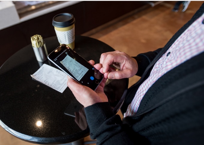 Close up of a mobile phone taking a photo of a receipt for coffee